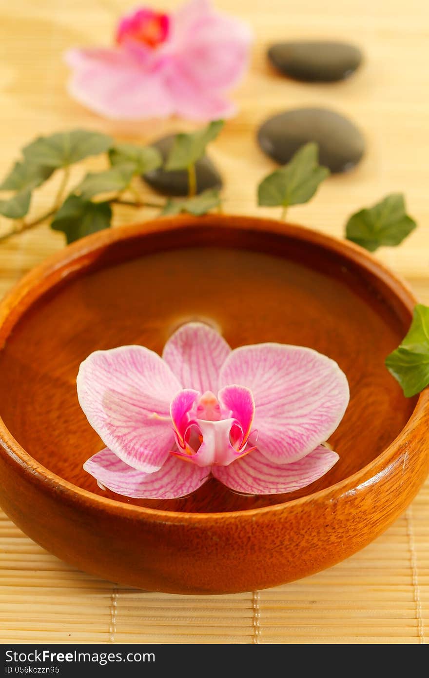 Spa concept with stones, pink orchids and water