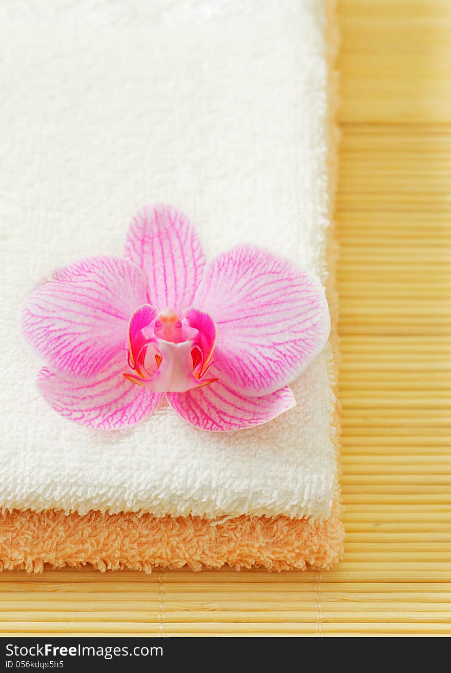 Stack of towels with pink orchid flower. Stack of towels with pink orchid flower