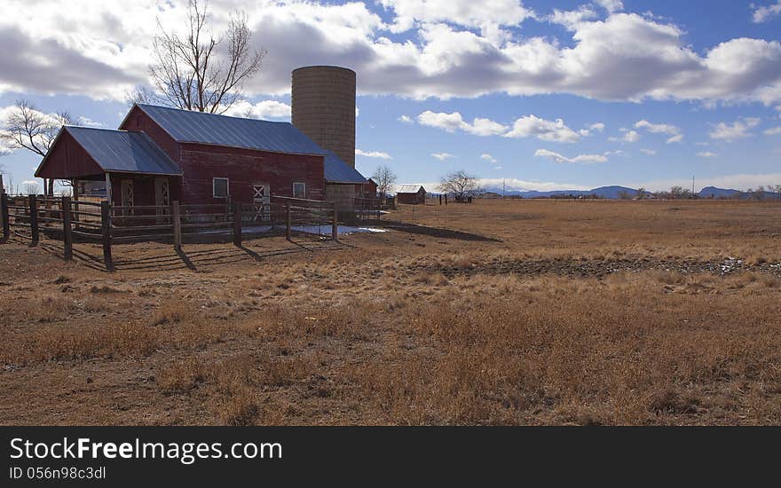 A red barn and ranch with silo on the plains of the Rocky Mountains. A red barn and ranch with silo on the plains of the Rocky Mountains.