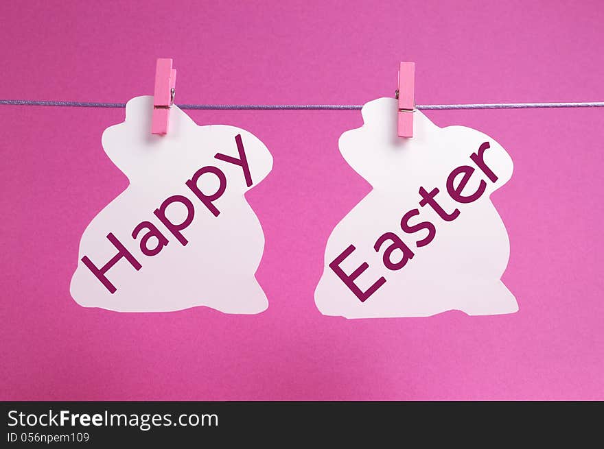 Two bunny rabbit shape Easter cards hanging from pegs on a line, with Happy Easter message in pink.