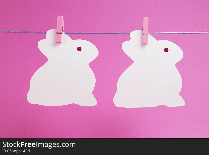 Pink theme two bunny rabbit shape Easter cards hanging from a line, with copy space for your text here.