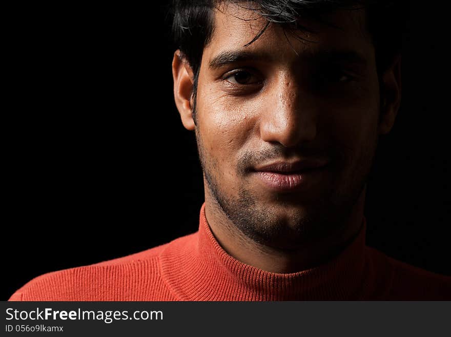 Portrait Of Young Indian  Man Smiling Over Dark