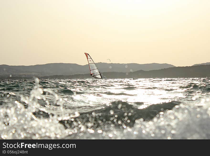 Backlight photo Day of sun wind surfer on spot and in the foreground kite surfing on the beautiful background. Backlight photo Day of sun wind surfer on spot and in the foreground kite surfing on the beautiful background.