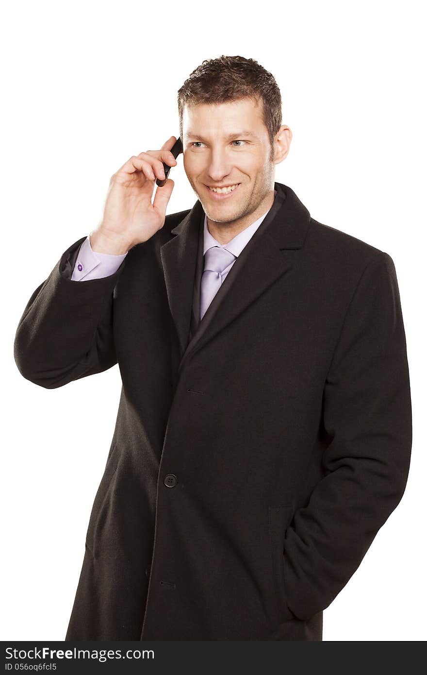 Smiling man in a coat telephones on white background