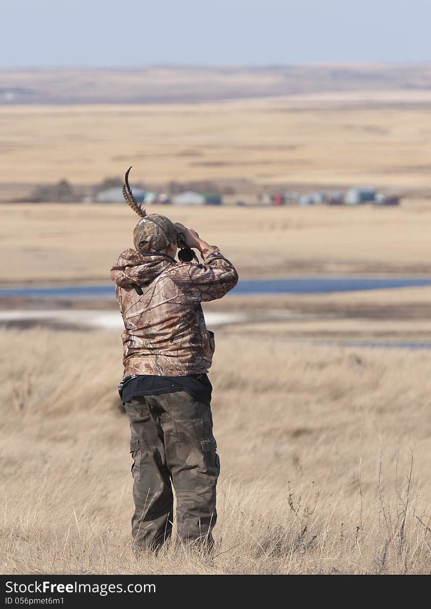 Boy looking for game with binoculars. Boy looking for game with binoculars