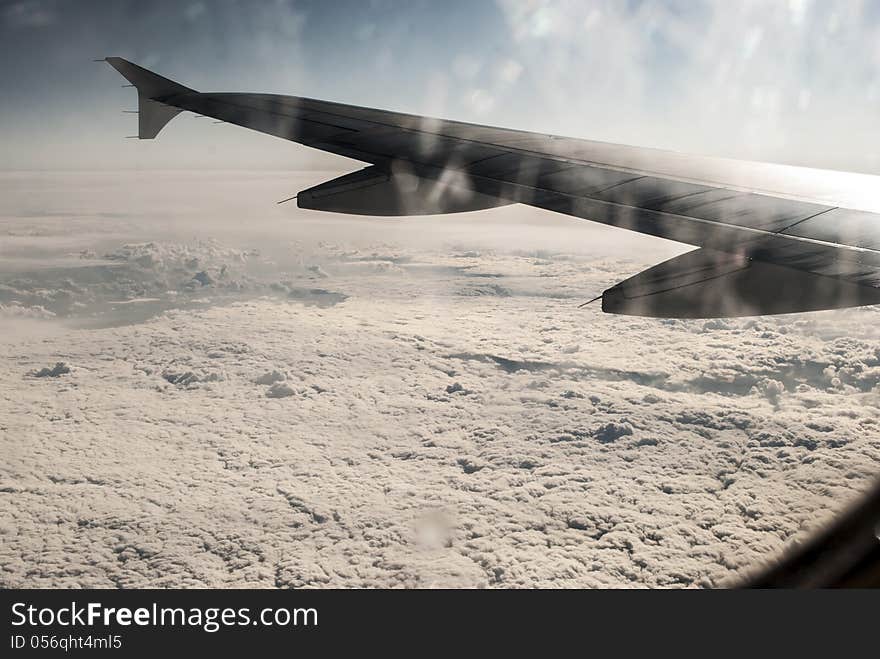 Frosty patterns at a plane window at height over clouds. Frosty patterns at a plane window at height over clouds