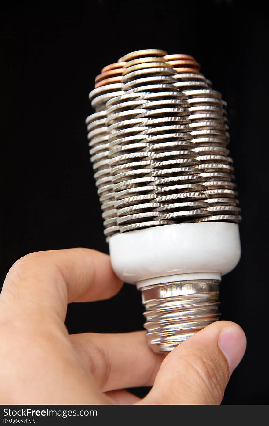 Hand holding coin light bulb concept