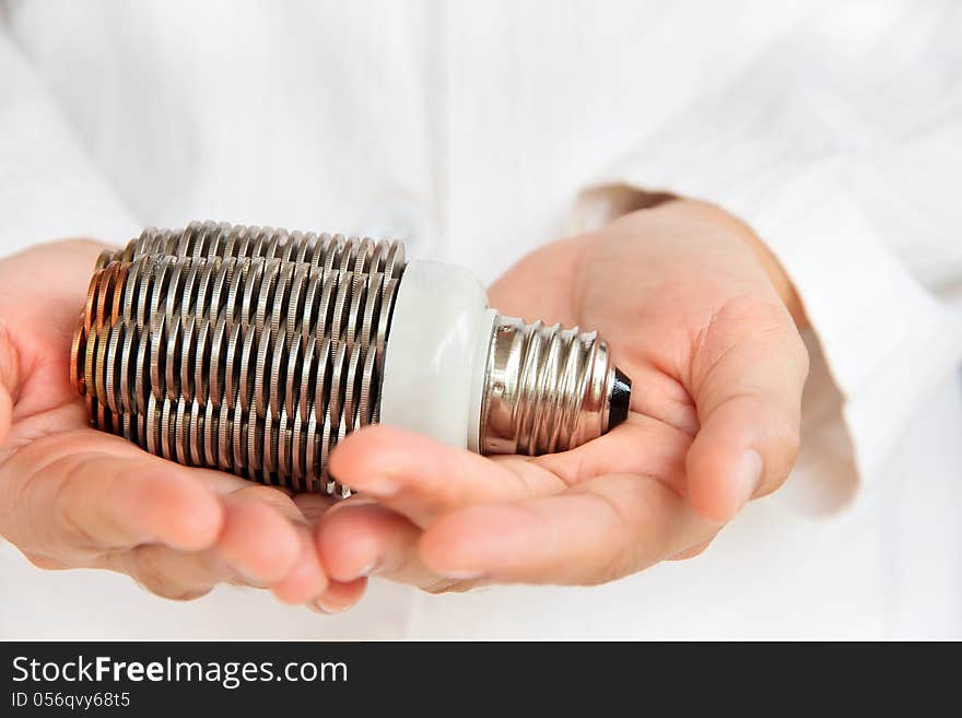 Hand holding coin light bulb concept