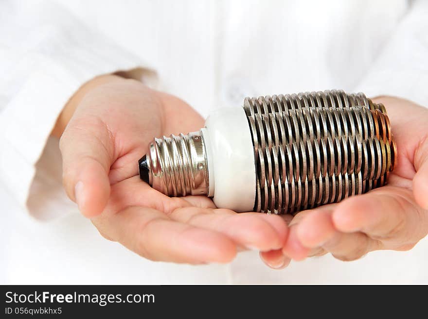 Hand holding coin light bulb concept