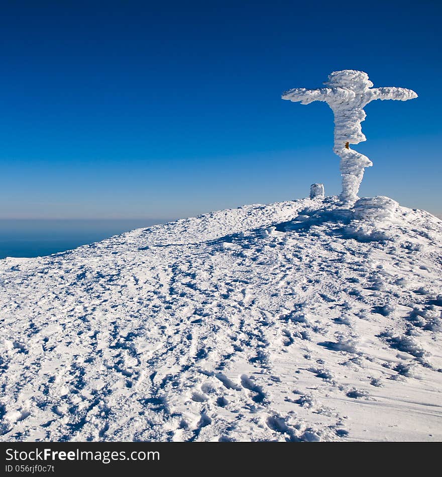 Winter top of the mountain with a cross