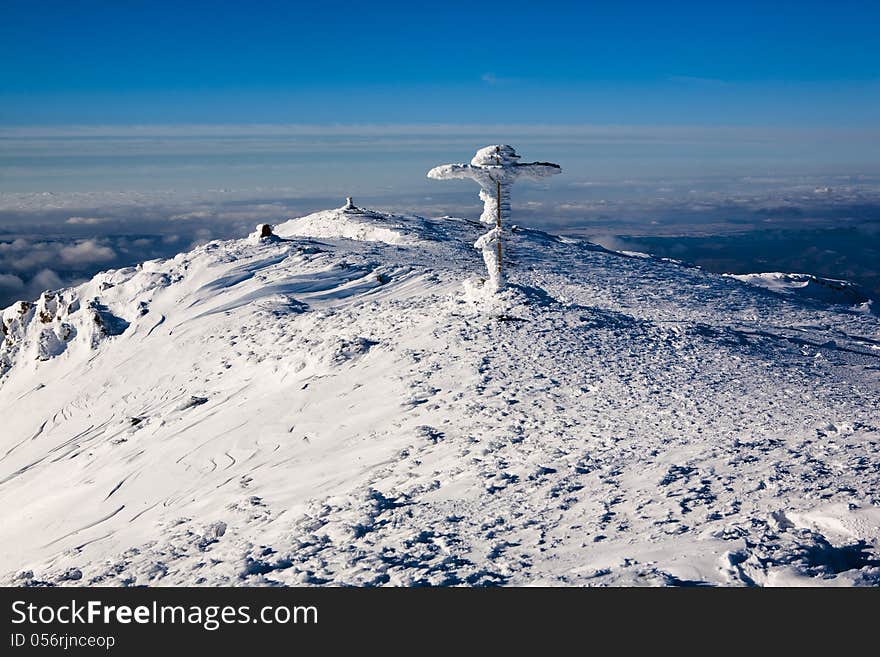 Winter top of the mountain with a cross