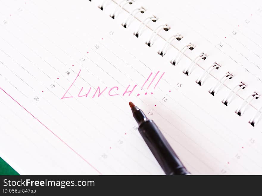 Diary with a reminder of the lunch and red marker. Diary with a reminder of the lunch and red marker