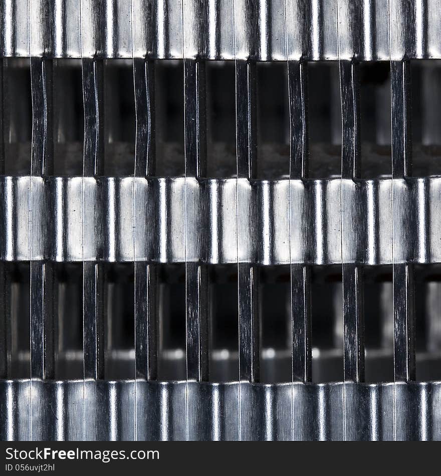 An abstract macro of a modern baseboard radiating heat element with aluminum fins.  A very geometric design. An abstract macro of a modern baseboard radiating heat element with aluminum fins.  A very geometric design.