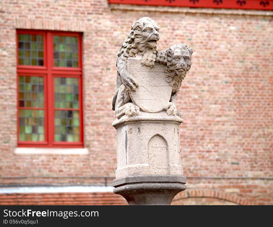 Statue of two lions guarding the shield, on way to the Market Square, Bruges, Belgium. Statue of two lions guarding the shield, on way to the Market Square, Bruges, Belgium