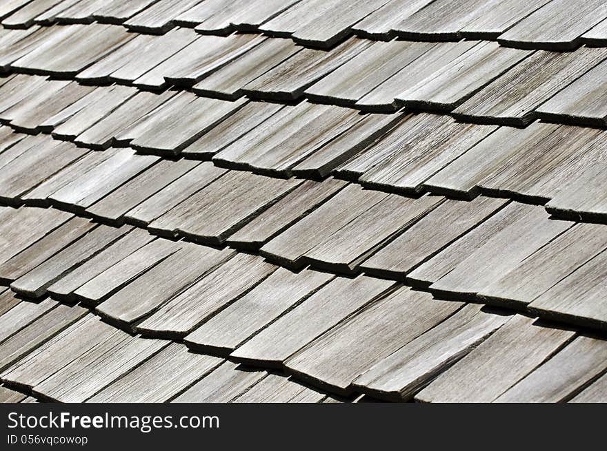 Raw of old black wooden tiles on an old house roof