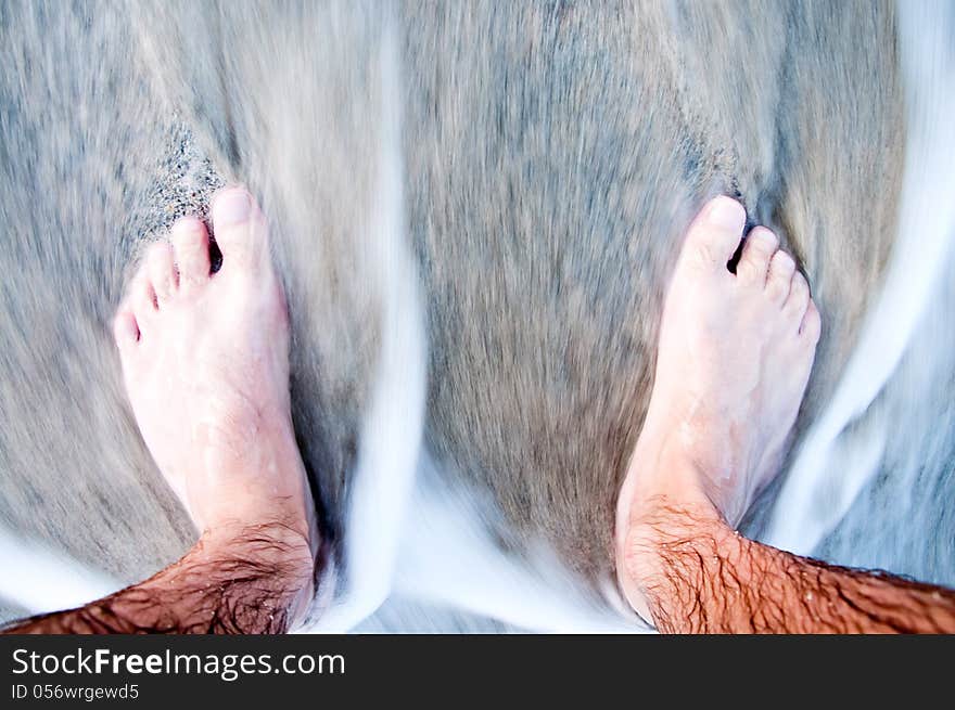 Feet of the man in the sea close-up. Feet of the man in the sea close-up