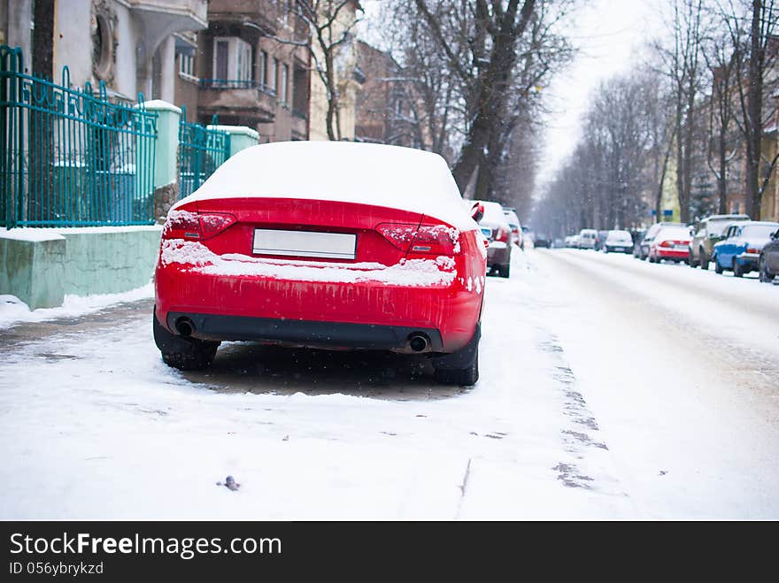 Red parked car near road in the city