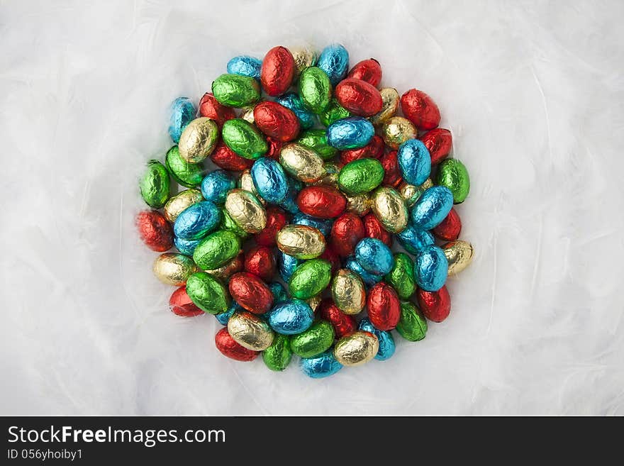 Chocolate easter eggs in colorful aluminium foil on down. Chocolate easter eggs in colorful aluminium foil on down