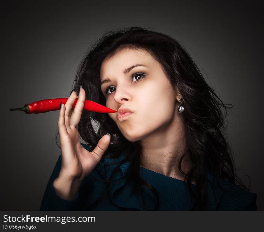 Woman Holding Red Hot Chili Pepper In Mouth