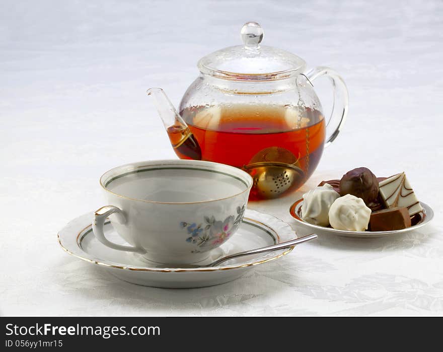 Cup On A Saucer, Teapot And Chocolates