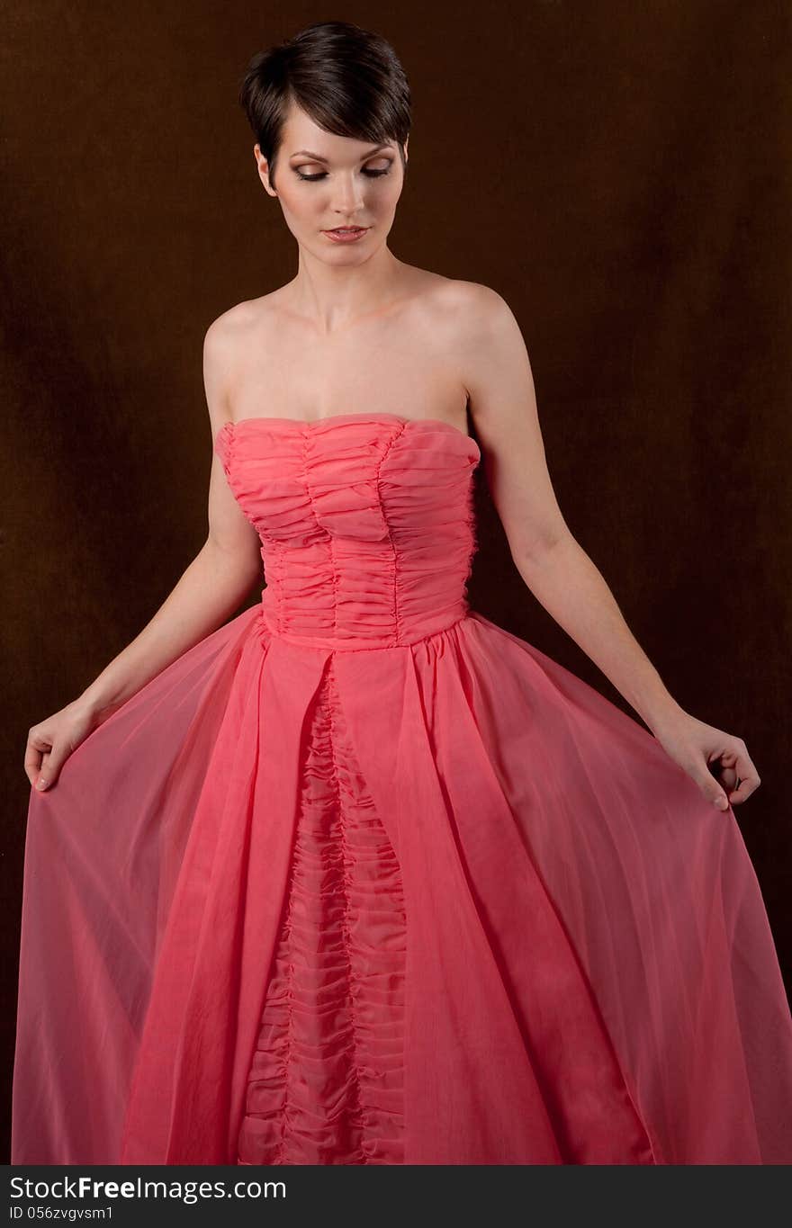 An image of a young woman in a pink strapless gown. An image of a young woman in a pink strapless gown