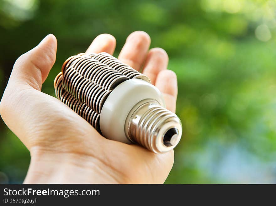 Hand holding coin light bulb