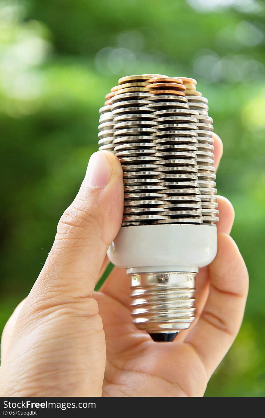 Hand holding coin light bulb