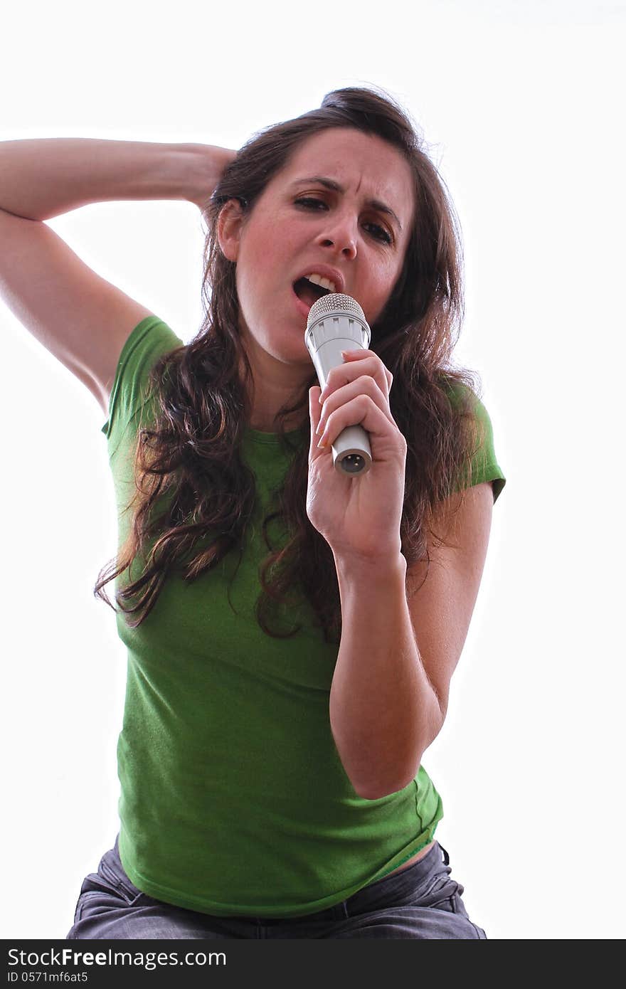 Caucasian female running her fingers through her hair singing a song through a microphone. Caucasian female running her fingers through her hair singing a song through a microphone