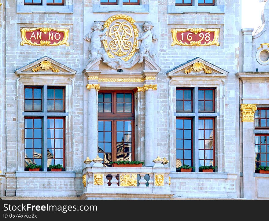 Grand Place In Brussels. Architectural detail at the Grand place statue on the wall. Large windows and a beautiful balcony. Belgium. Grand Place In Brussels. Architectural detail at the Grand place statue on the wall. Large windows and a beautiful balcony. Belgium.