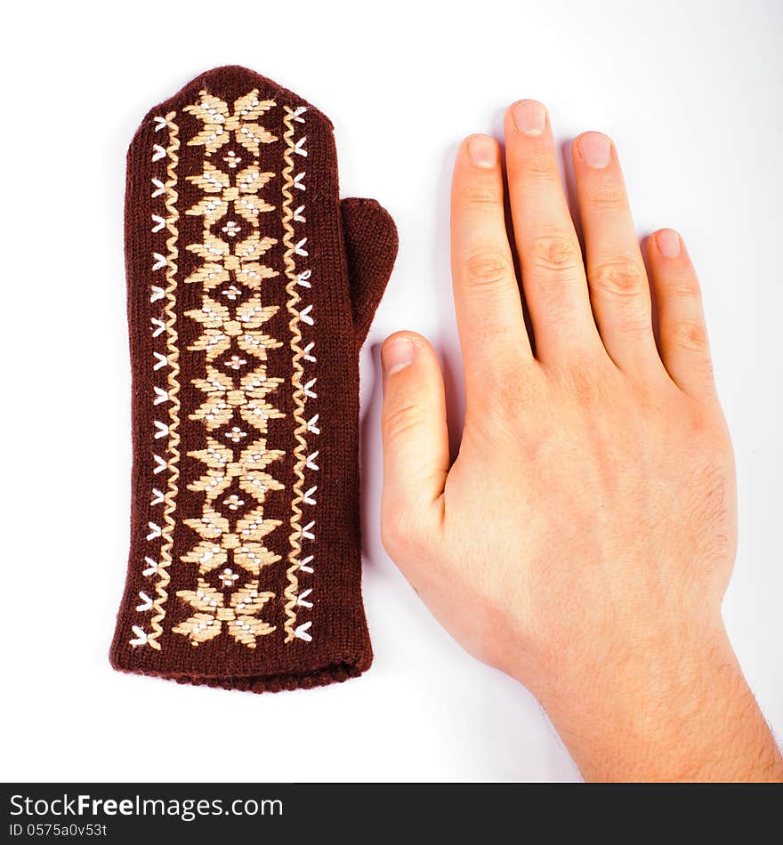 Brown woolen knitted mitten and hand on white background. Brown woolen knitted mitten and hand on white background