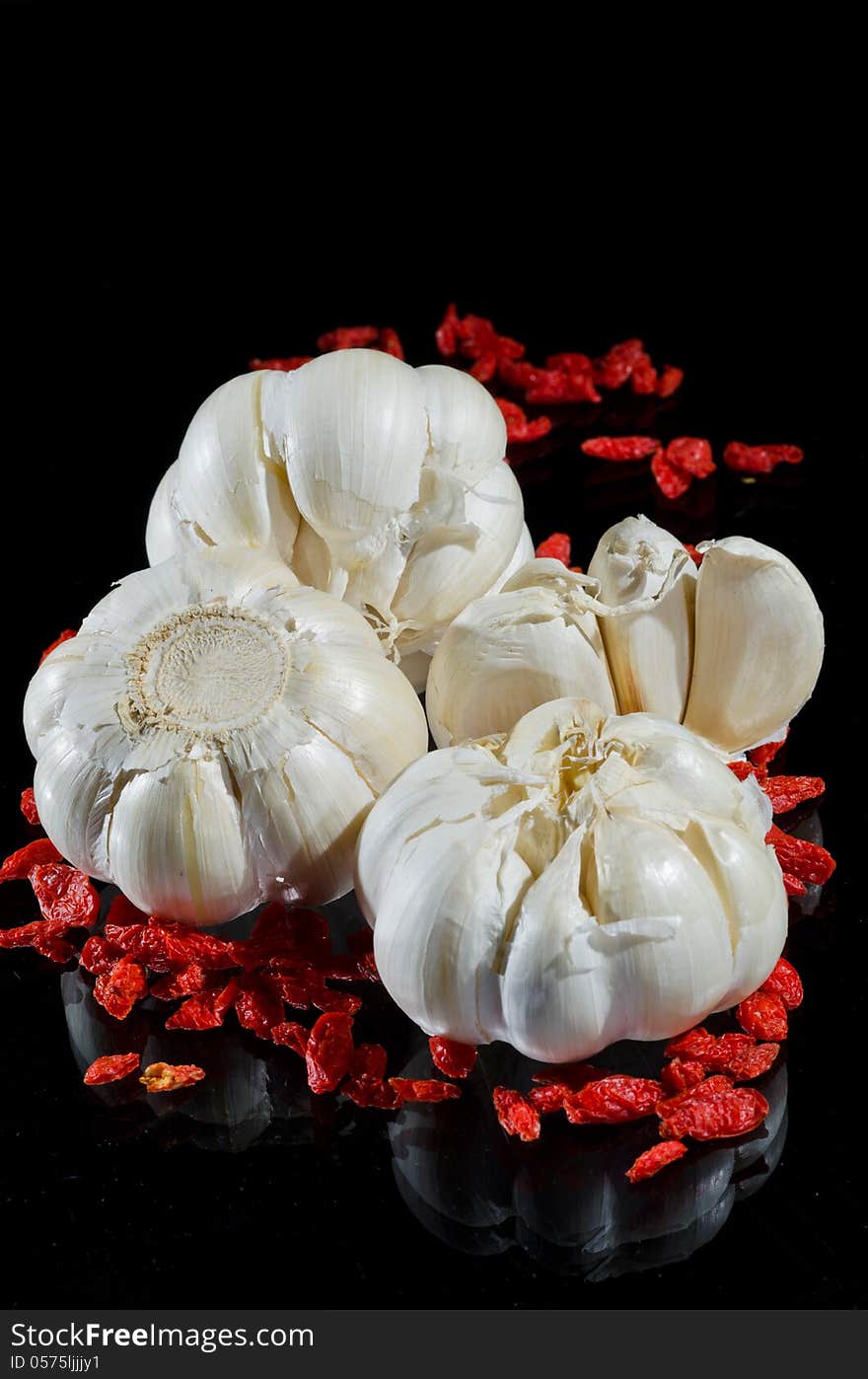 Garlic and wild rose seed on black background. Garlic and wild rose seed on black background