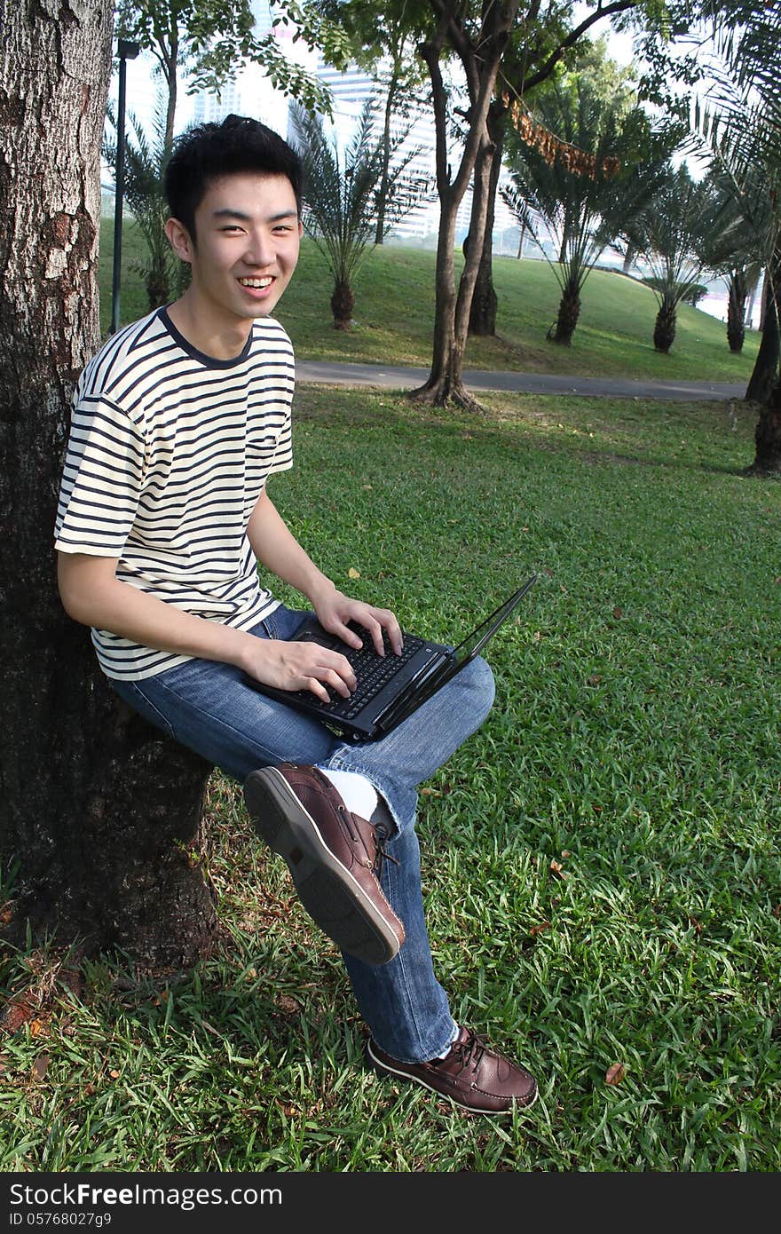 Young asian man working in the park