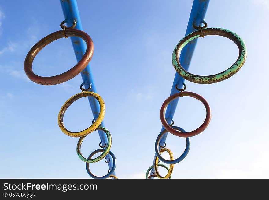 Rusty colored metallic rings over blue sky. Rusty colored metallic rings over blue sky