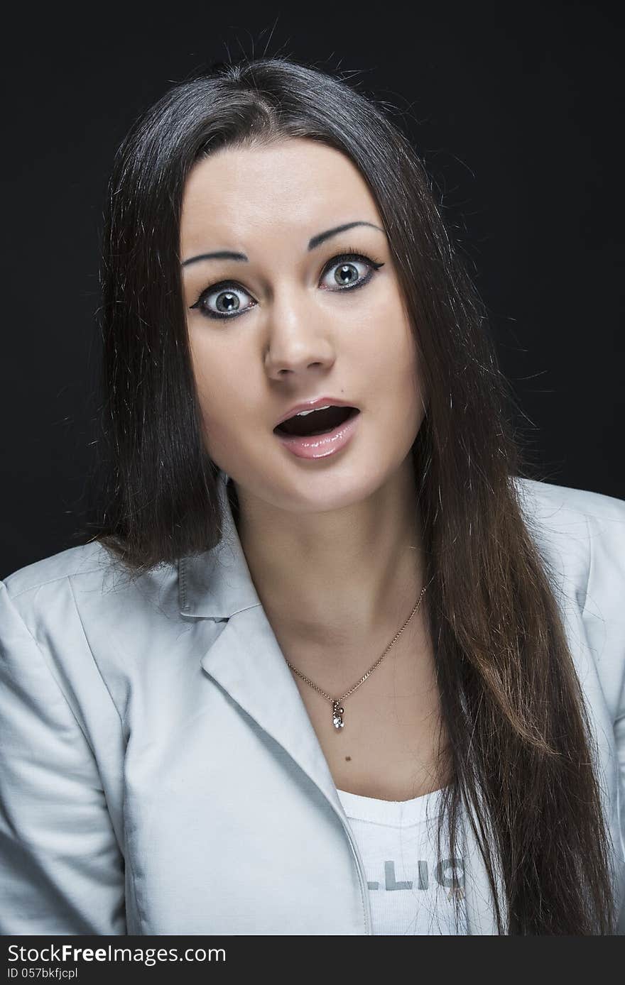 Three quarter shot of young woman leaning over with shocked expression. Three quarter shot of young woman leaning over with shocked expression.