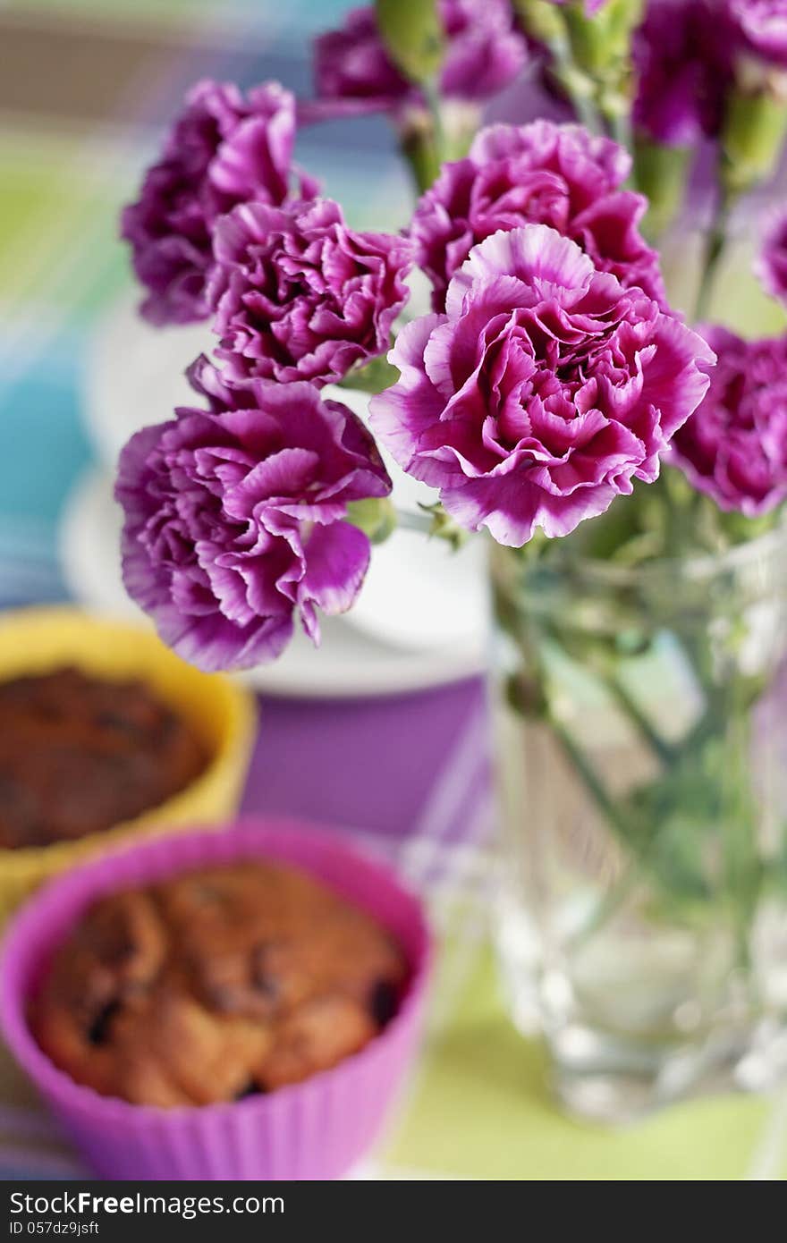 Purple Carnations And Maffins On The Table