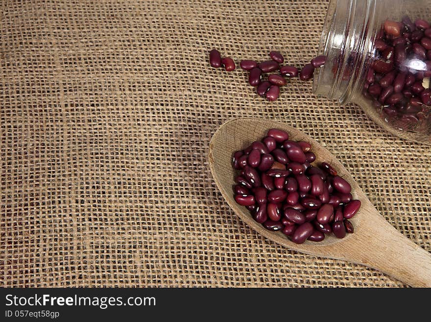 Spilled black beans out of a mason jar and black beans in a spoon background. Spilled black beans out of a mason jar and black beans in a spoon background