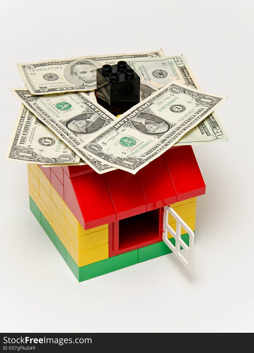 LEGO house and money. Dollars on the roof.