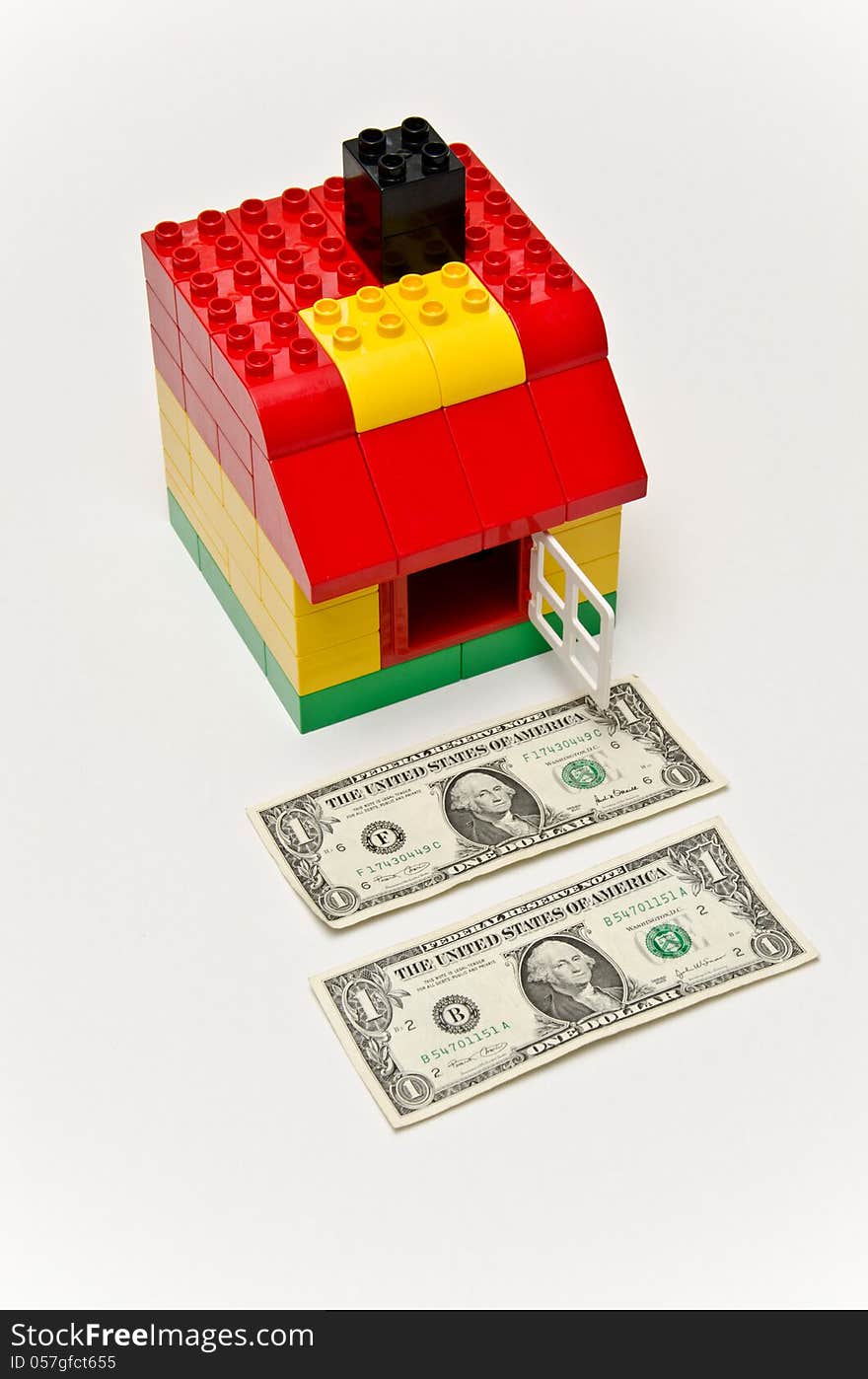 LEGO house and money. Dollars in front of the house.