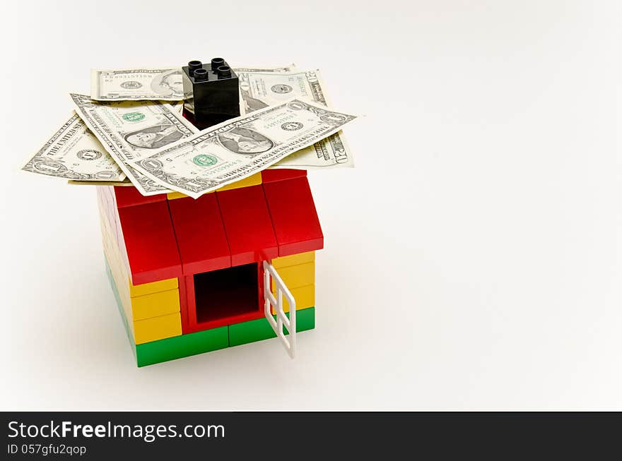 LEGO house and money. Dollars on the roof.