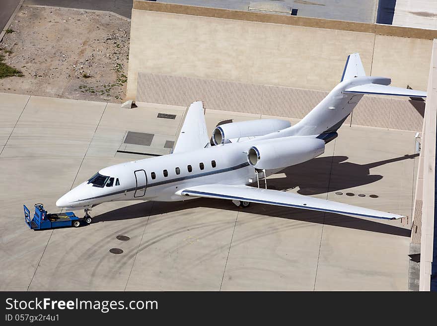 Small Jet parked in front of hanger from above