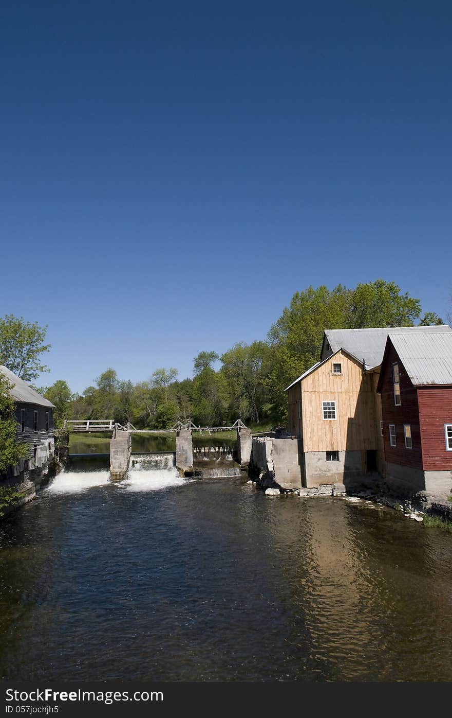 Old mill on the creek with large copy area in the deep blue sky