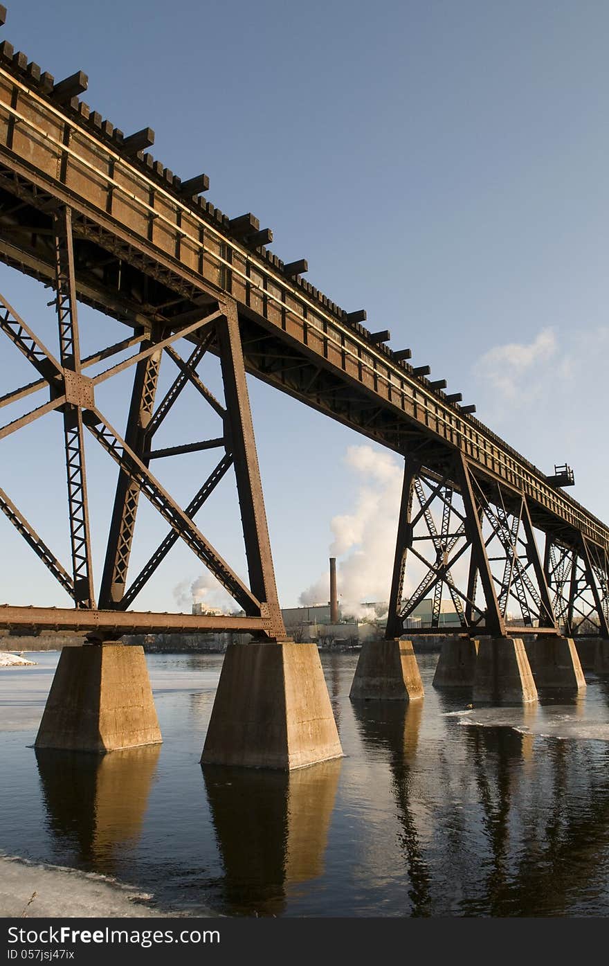 Factory in the background with train bridge in the foreground. Factory in the background with train bridge in the foreground