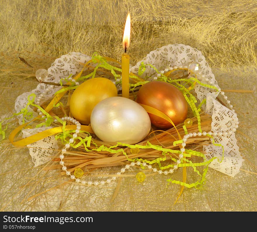 Three gold easter eggs with candle and beads