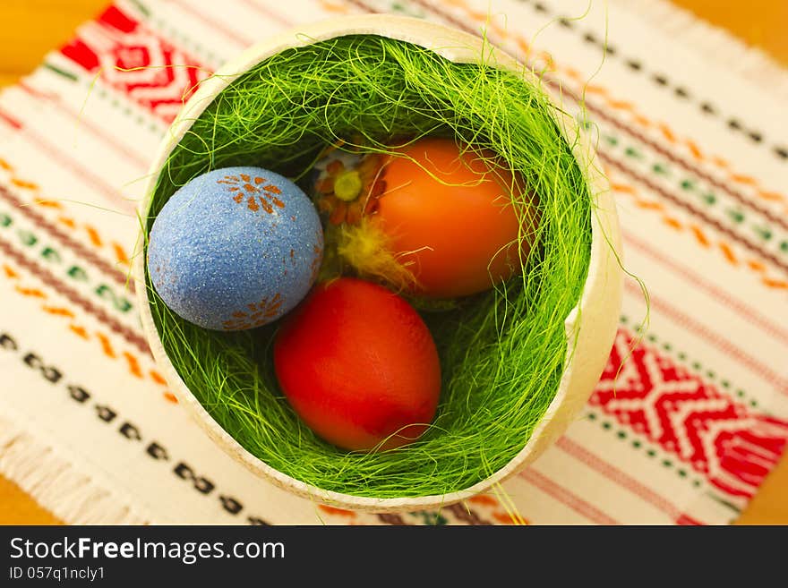 Colored Easter eggs in one big ostrich egg with grass.