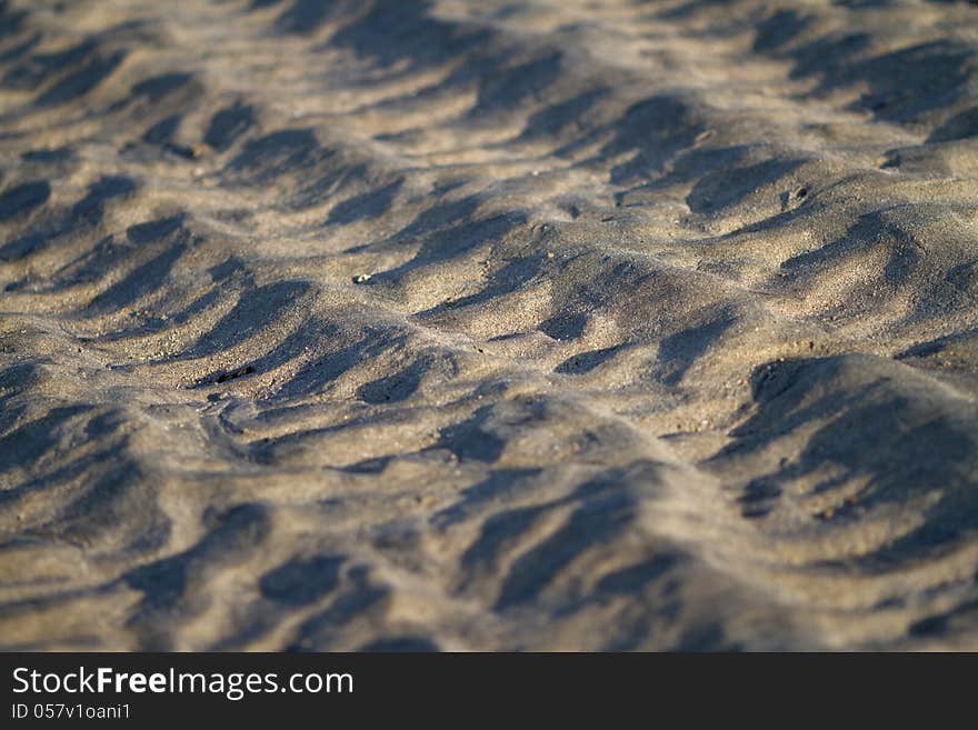 Texture of the gray beach sand  during the morning sidelight