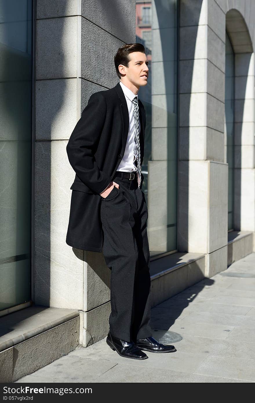 Portrait of attractive young businessman in urban background