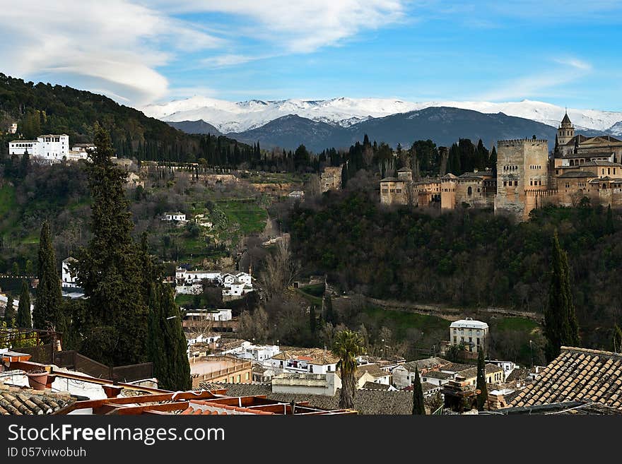 Aerial view of Alhambra and snowing Sierra Nevada mountains under a lenticular cloud