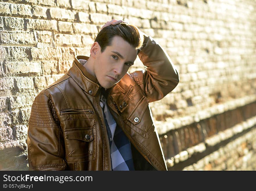 Portrait of handsome man with modern hairstyle in urban background