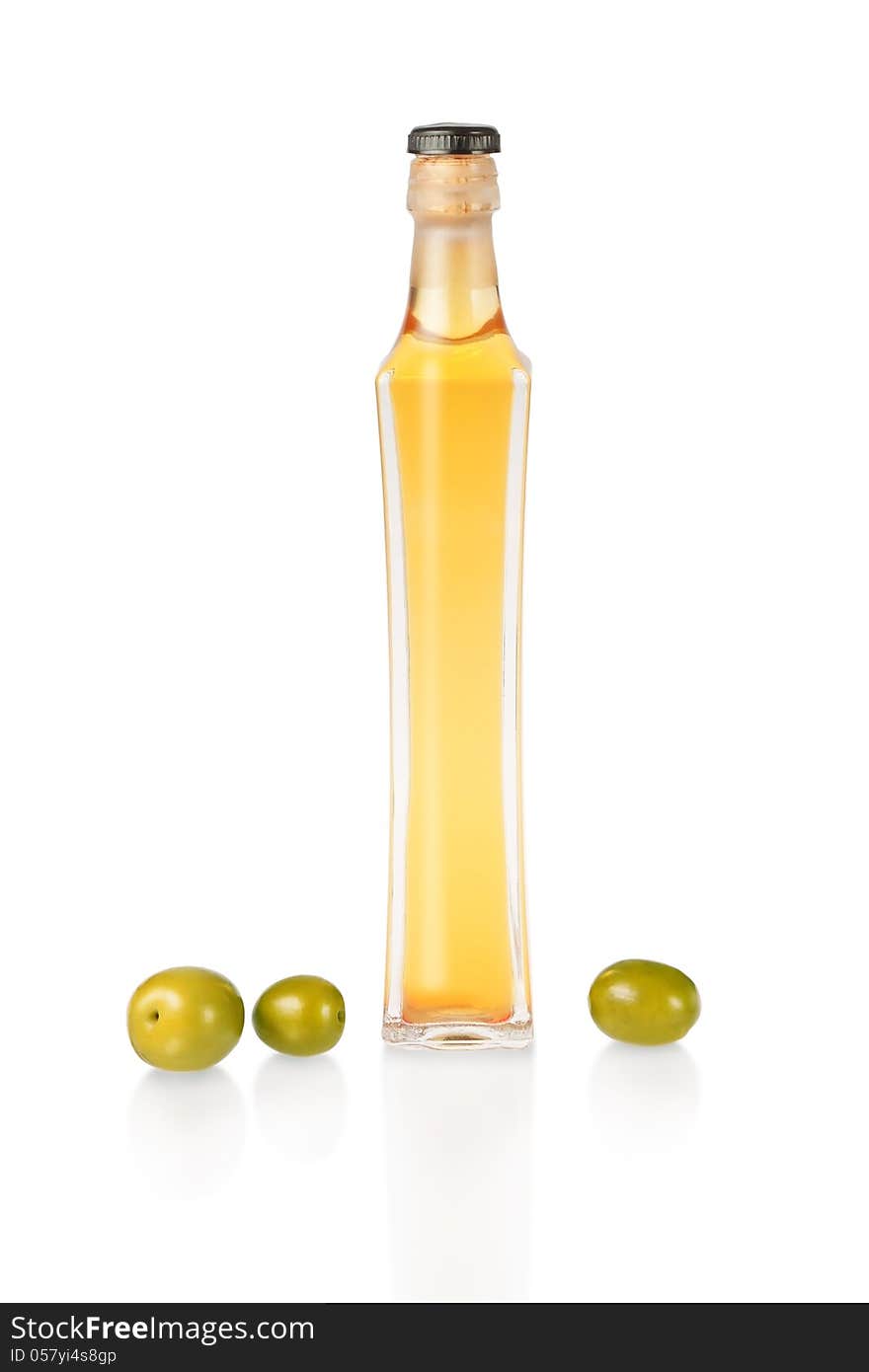 A bottle of olive oil and fresh green olives. On a white background.