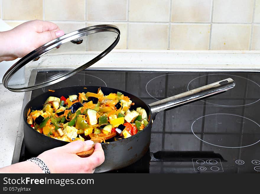 Cooking of stewed vegetables in pan on stove. Cooking of stewed vegetables in pan on stove